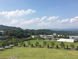緑の多い丘陵地にあり、自然と調和している播磨科学公園都市の芝生広場の写真