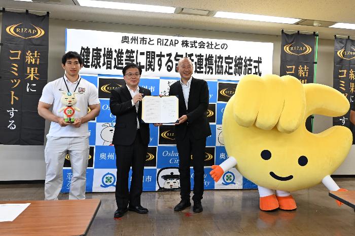 協定書を手にする倉成市長と村瀬本部長