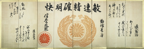 中央に鉄道院の徽章が描かれ、その上に「快明確精速敏」と墨で文字が書かれ、徽章の左右にも文章が墨で書かれている八曲屏風の写真