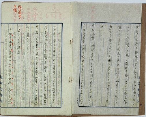 原稿用紙の見開きに、漢字と片仮名で文章が書かれ、朱色で文字を強調したり、欄外にメモが記載されている「書簡」の写真