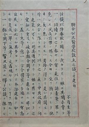 原稿用紙に漢字と片仮名で文章が 書かれている「連合公立医学校設立之儀ニ付建白」の最初のページを写した写真