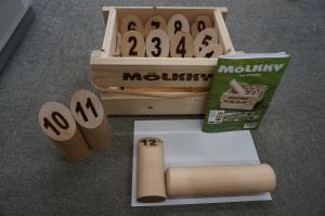 モルックと呼ばれる木製の棒と1から12の番号が入ったスキットルと呼ばれる木製のピンがセットになったモルックの道具の写真