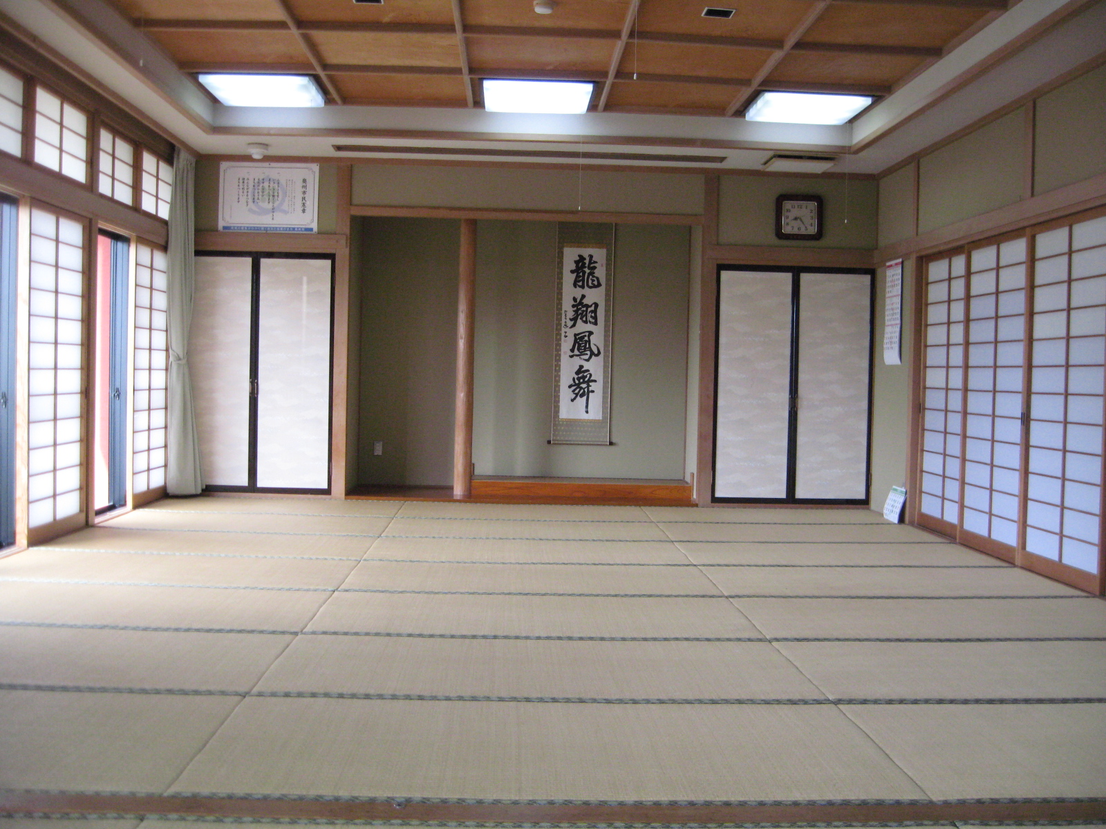 「龍翔鳳舞」と書かれた掛け軸が飾られている、畳が敷かれた和室の写真