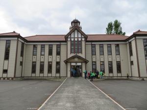 薄い朱色の屋根に、ベージュ色の外壁、窓が並んでいる大きな2階建ての宇宙遊学館の外観を正面から写した写真