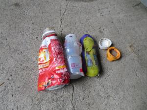 乳酸菌飲料の容器、ラムネ菓子の容器、ペットボトルのキャップが並べて置かれている写真