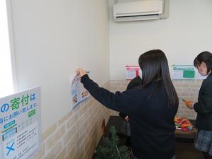 手元に置いた材料を使って作業をしている女子生徒と、壁にポップを貼ろうとしている女子生徒の写真