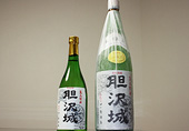 「胆沢城」の文字と鬼瓦と軒丸瓦の模様が描かれたラベルが貼り付けてある緑色のボトルがサイズ違いで2本置かれている写真