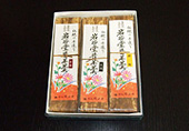 箱の中に竹の皮で包み、白い背景に「岩谷堂昔羊羹」の文字とピンクやオレンジ色の花のイラストが描かれたシールを表面に貼った、3種類の羊羹が入っている写真
