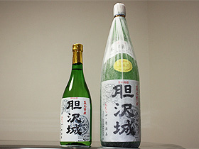 「胆沢城」の文字と鬼瓦と軒丸瓦の文様が描かれたラベルが貼り付けてある緑色のボトルがサイズ違いで2本置かれている写真