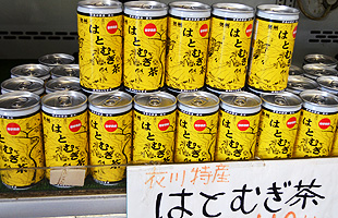 黄色いパッケージの衣川特産はとむぎ茶の缶が棚に沢山並んでいる写真