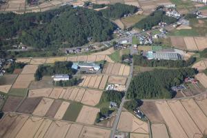 住宅や田んぼ、緑豊かな木々に囲まれた胆沢東部工業団地を上空から写した写真