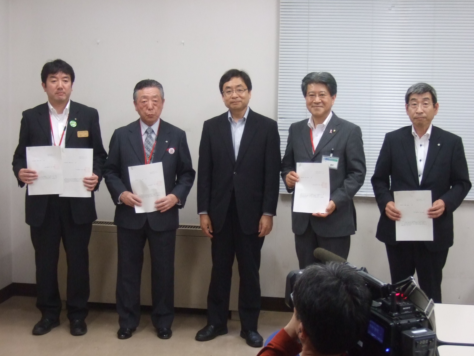 連結許可書を持った小沢市長と4名の男性が横一列に並んで立っている集合写真