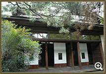 松の葉が垂れ下がる庭の奥に、白い障子で仕切られた和室や木造の切目縁が施された日本家屋の高野長英旧宅の外観写真