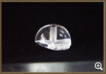 T字形に穴が開いている直径2センチメートルの水晶製数珠玉の写真