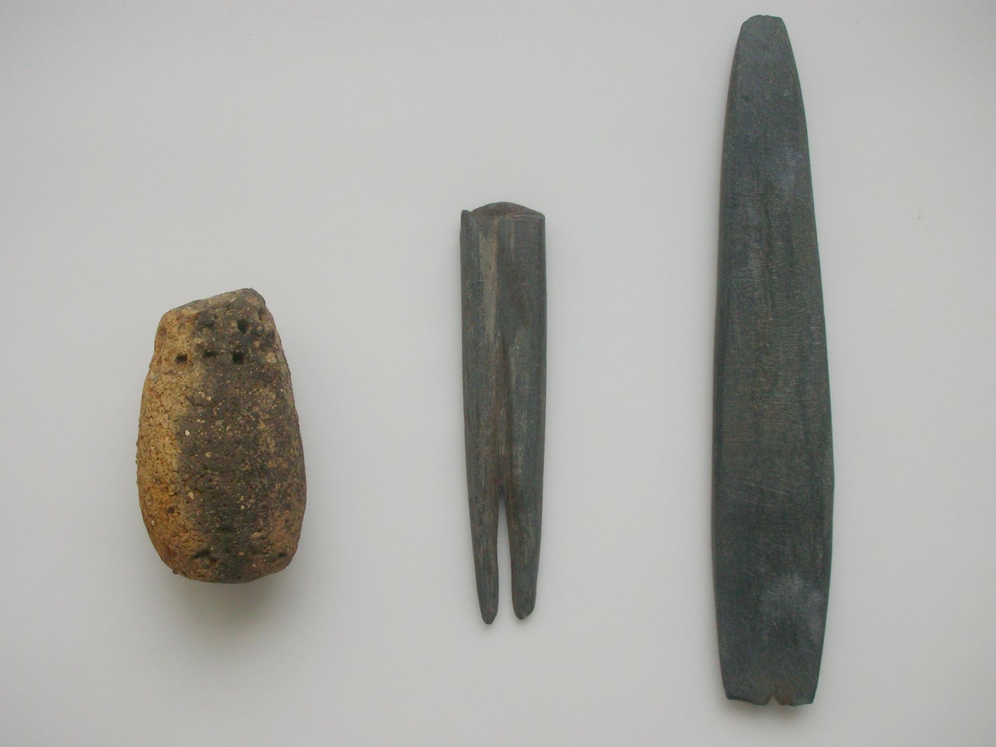 左から、茶色のイチジク形土製品、先端が2つに分かれた黒っぽい燕尾形石製品と、先端が鋭利になるよう削られた黒っぽい燕尾形石製品の写真
